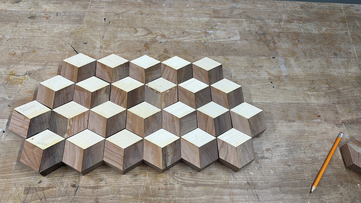 Array of hand-glued hexagon cubes curing on the workbench