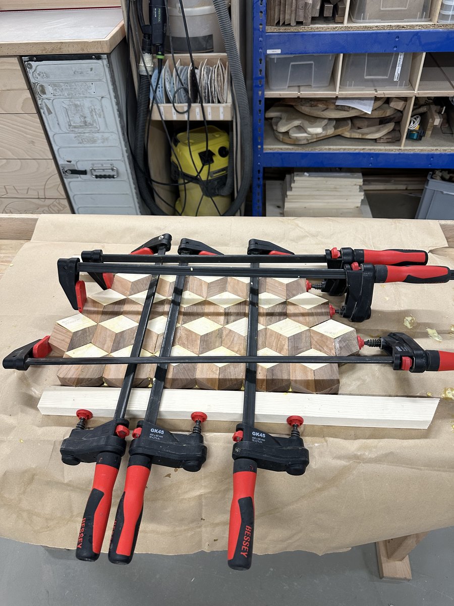 Cured glued board out of clamps showing squeeze-out and stepped zigzag ends