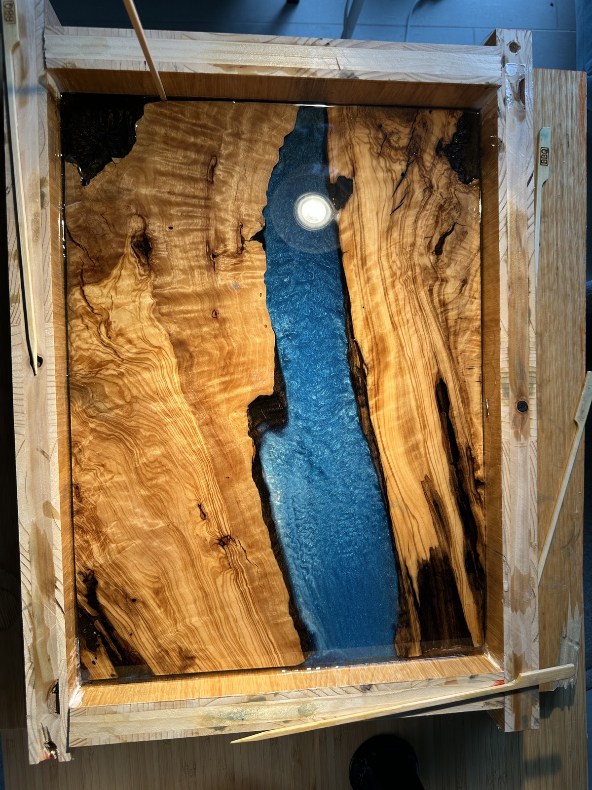 First blue mica epoxy pour filling the river cavity