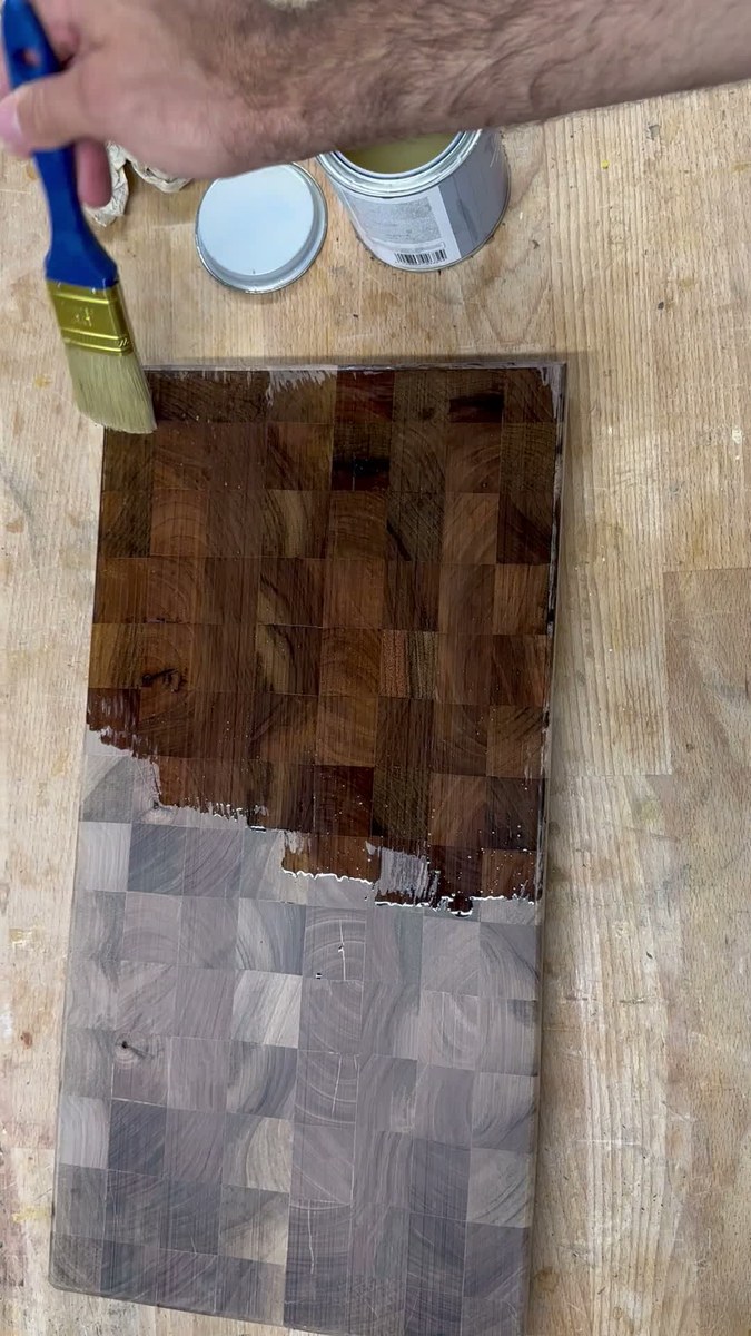 First brush stroke of mineral oil transforming raw walnut into dark chocolate end-grain