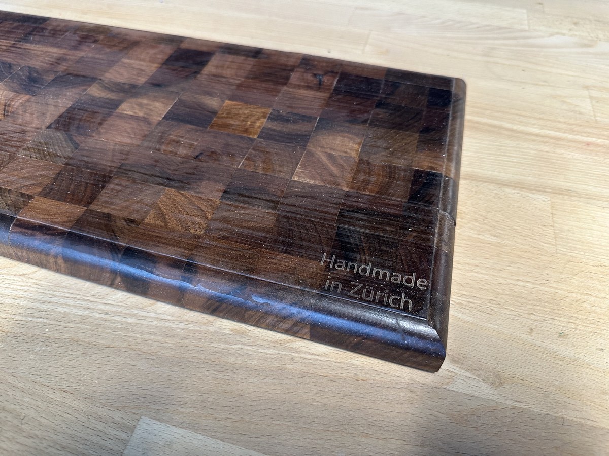 Close-up detail of routed perimeter juice groove and 'Handmade in Zürich' engraving